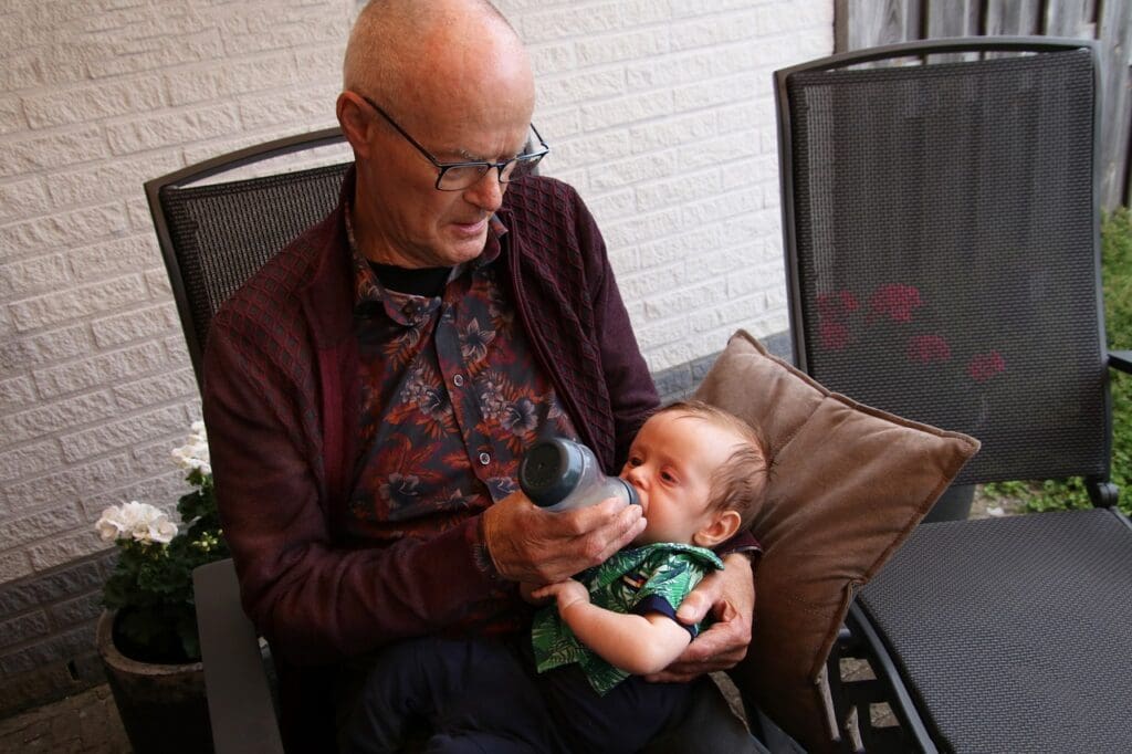 Grandfather feeding baby