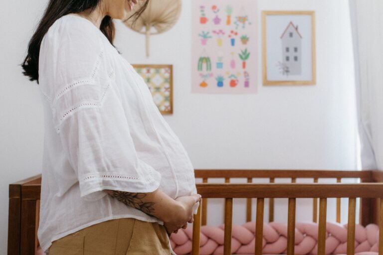 https://www.pexels.com/photo/a-pregnant-woman-stands-in-front-of-a-crib-28096433/